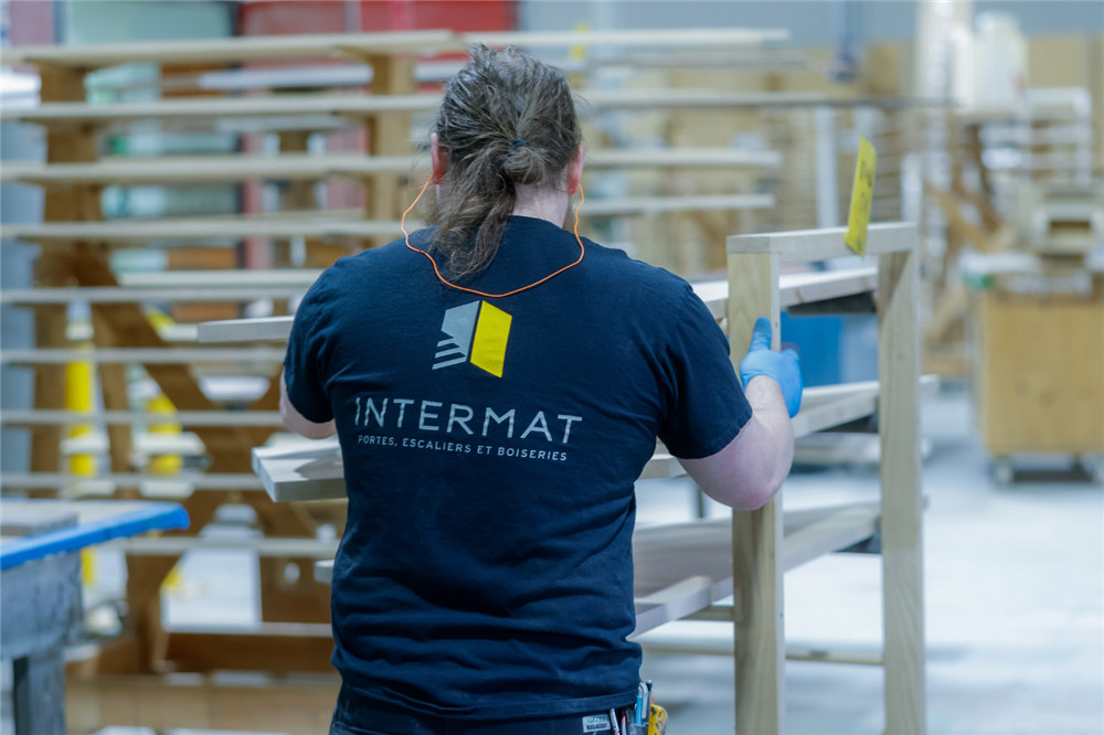 Employé d’Intermat en atelier manipulant des éléments de finition intérieure, illustrant l’expertise d’un fournisseur spécialisé en finition intérieure.